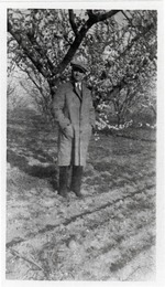 Man standing in front of blossoming tree.